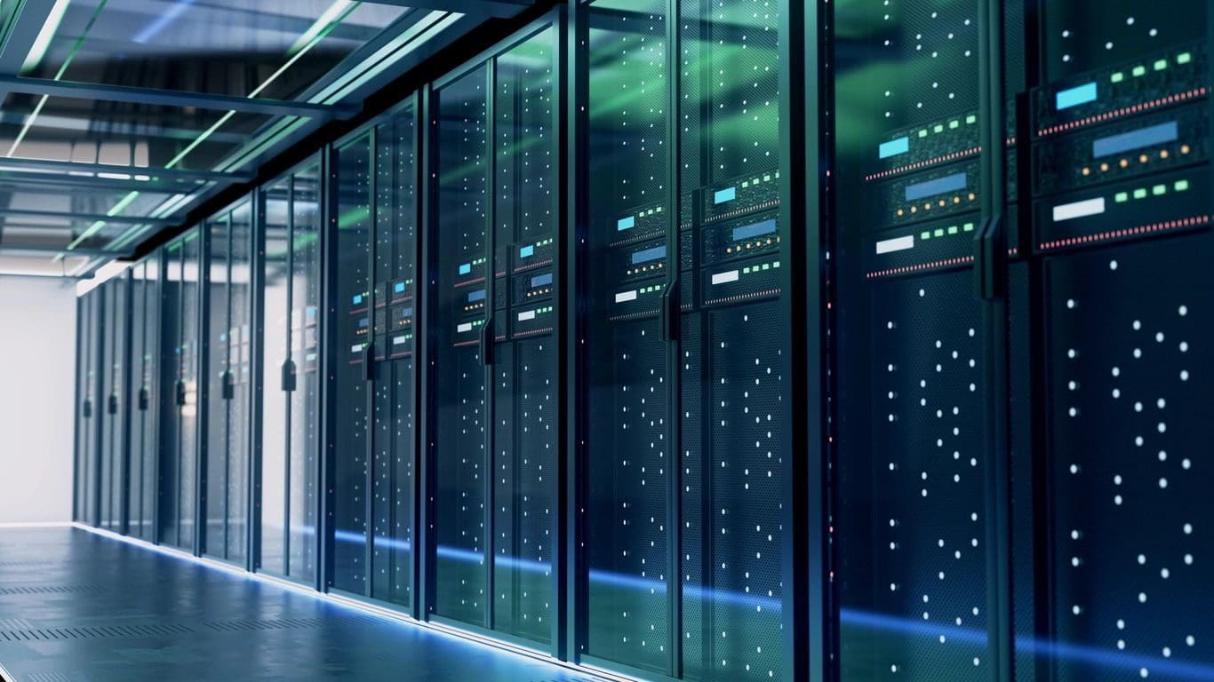A modern data center with rows of server racks and illuminated green and blue lights reflecting on the floor and ceiling.